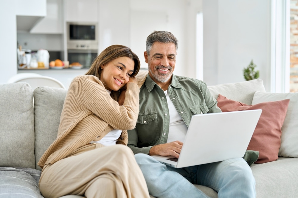 Happy,Middle,Aged,Couple,Using,Laptop,Relaxing,On,Couch,At Hormone Pellet Therapy in Sugar Land, TX